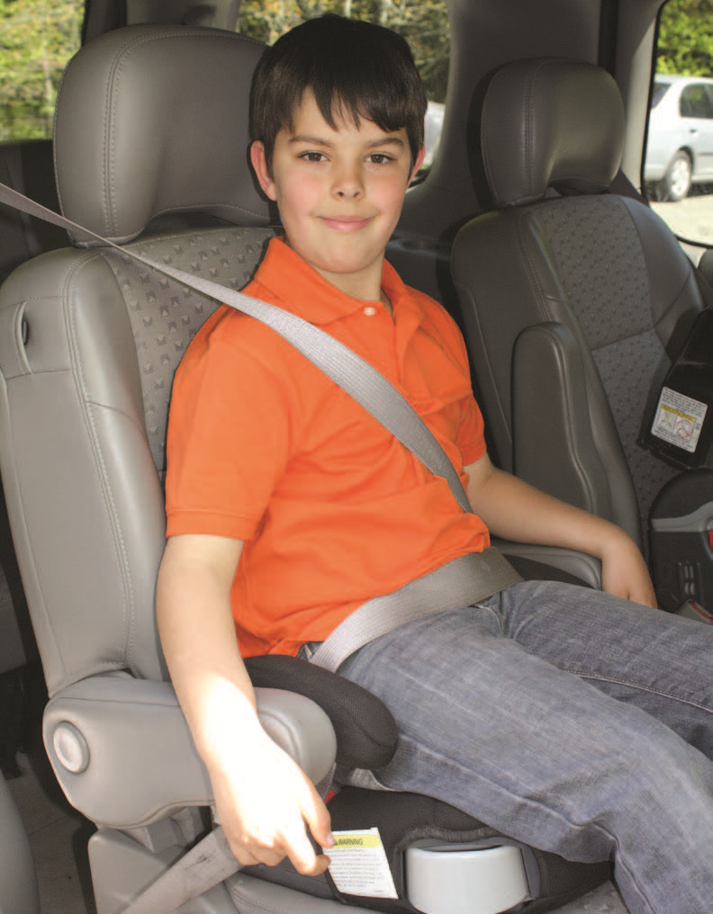 Child sitting on a backless booster seat, buckled into the seat with the seat belt.