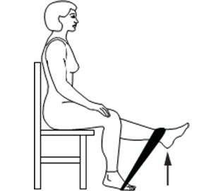 Woman sitting on a chair, with a rubber band stretched between both feet. She is raising one leg against gravity and the rubber band.