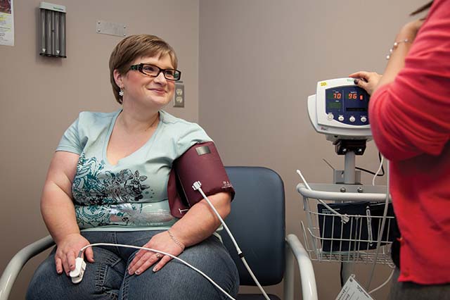 Healthcare provider taking a person's blood pressure and pulse measurements.