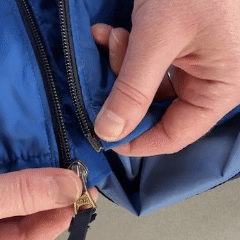Close up of hands zipping up a coat. Hands are doing different movements.
