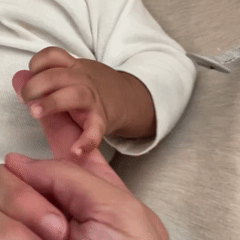 Close up of newborn’s hand grabbing a person’s finger.