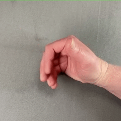 Close up of thumb pressing down on the side of curled-up fingers. How a hand might grab a ticket from a machine.